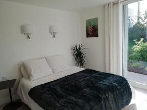 Un dormitorio con una cama grande y una ventana en Esprit Cottage "4 étoiles" sables d'Or les pins en Plurien
