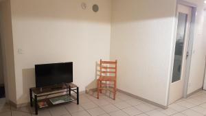 a living room with a tv and a chair at Gites de la combe in Bramans