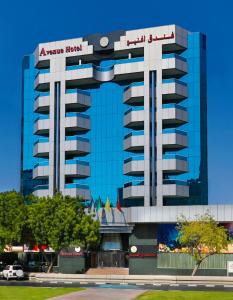 a large building with a sign on top of it at Avenue Hotel Dubai in Dubai