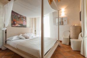 1 dormitorio con 1 cama blanca con dosel en Fontanile Relais - Valcalepio Lounge en Gandosso