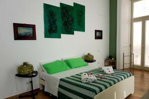 ナポリにあるLo Specchio dei Papiriのベッドルーム1室(緑と白のシーツが備わるベッド1台付)