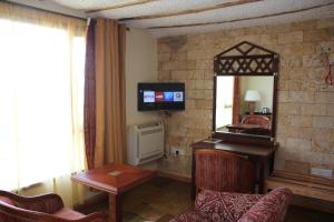 a living room filled with furniture and a tv at Afrika Lodges in Voi