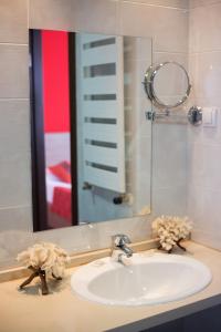 La salle de bains est pourvue d'un lavabo et d'un miroir. dans l'établissement Hotel Putnik, à Novi Sad
