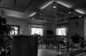 un ristorante con tavoli e sedie e un bar di Guesthouse Evi Maria a Ángistron