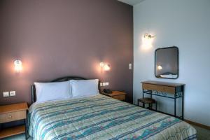 1 dormitorio con 1 cama y TV en la pared en Guesthouse Evi Maria en Ángistron
