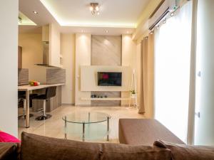 uma sala de estar com uma mesa de vidro e uma televisão em DK Mini Suites A em Tessalónica