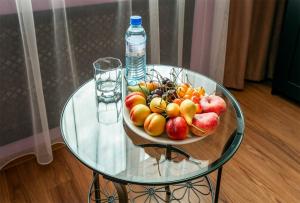 un bol de fruta en una mesa de cristal con una botella de agua en Cheremushki Hotel en Moscú