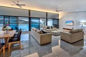 ein Wohnzimmer mit Sofas und einem Tisch in der Unterkunft Waves 5 Luxury 3 Bedroom Breathtaking Ocean Views Central Location in Hamilton Island