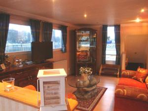 ein Wohnzimmer mit einem Sofa und einem TV in der Unterkunft Hotelschiff Perle Bremen in Bremen