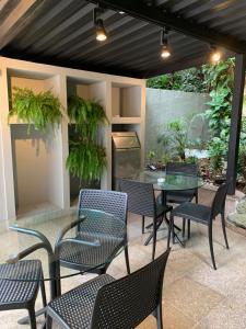een patio met tafels, stoelen en planten bij Hotel Village Icaraí in Niterói