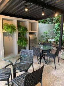 a patio with tables and chairs and plants at Hotel Village Icaraí in Niterói