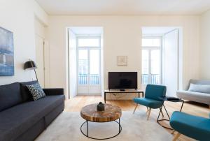 een woonkamer met een bank en een tafel bij FLH Chiado Modern Apartment in Lissabon