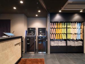a room with two refrigerators and a counter with towels at Super Hotel Premier Akihabara in Tokyo