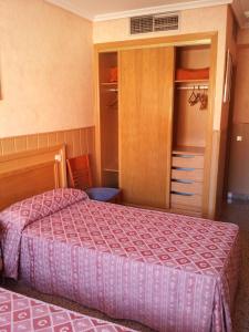 a bedroom with a bed and a closet at Hostal Juan XXIII in San Sebastián de los Reyes