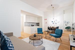 uma sala de estar com um sofá, cadeiras e uma mesa em FLH Chiado Trendy Apartment em Lisboa