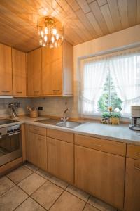 a kitchen with wooden cabinets and a sink and a window at Schwallenberg 2 in Adenau