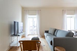 uma sala de estar com um sofá e uma televisão em FLH Bairro Alto Modern Flats em Lisboa