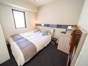 a bedroom with a large bed and a window at Super Hotel Premier Akihabara in Tokyo