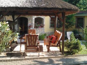 a wooden gazebo with two chairs and a table at Mediterrán Apartmanház Szántód in Szántód