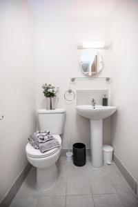 a white bathroom with a toilet and a sink at Trivelles Seaview Blackpool in Blackpool