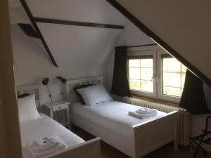 two beds in a room with two windows at B&B de Druif in Breda