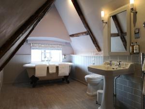 ein Badezimmer mit Badewanne und Waschbecken und einem Fenster in der Unterkunft Crown Hotel in Southwold
