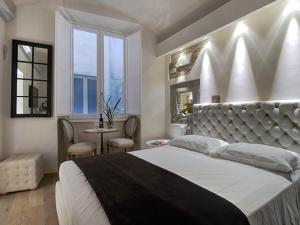 ein Schlafzimmer mit einem großen Bett und einem Tisch mit Stühlen in der Unterkunft Piccolo Signoria Apartment in Florenz