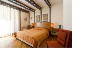 a bedroom with a bed and a chair and a window at Casa Rossella in Sorrento