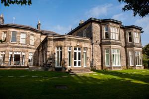 a large brick house with a lawn in front of it at Halifax Hall in Sheffield