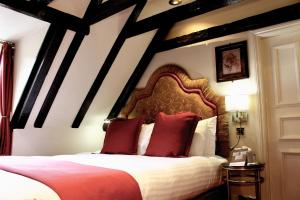 a bedroom with a large bed with red pillows at Lumley Castle Hotel in Chester-le-Street