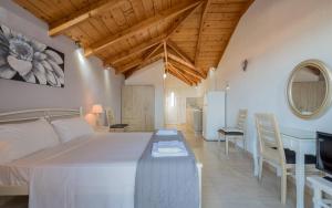 a bedroom with a large bed and a table and chairs at Yiannis Studios in Tsilivi