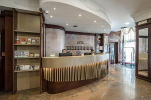 a lobby with two people sitting at a bar at Hotel Mythos in Milan