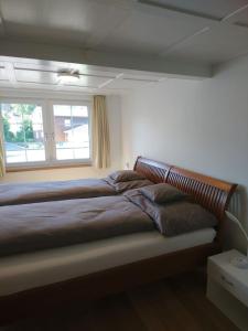 - une chambre avec un grand lit et une fenêtre dans l'établissement Zwinglis Ferienwohnung Klärli, à Nesslau