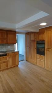 an empty kitchen with wooden cabinets and wooden floors at Zwinglis Ferienwohnung Klärli in Nesslau