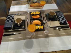 una mesa con platos de comida y vasos de zumo de naranja en B&B Speelmansrei en Brujas