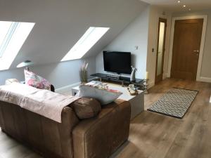 sala de estar con sofá y TV de pantalla plana en Lakeside Studio 1 Loft Apartment en Enniskillen