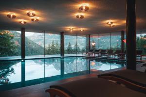 una camera d'albergo con piscina e vista sulle montagne di Hotel Arlara a Corvara in Badia