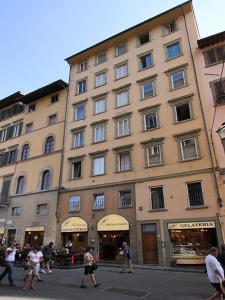 ein großes Gebäude mit Leuten, die davor laufen in der Unterkunft Piccolo Signoria Apartment in Florenz