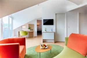 ein Wohnzimmer mit 2 Stühlen und einem Tisch in der Unterkunft Welcome Hotel Marburg in Marburg an der Lahn