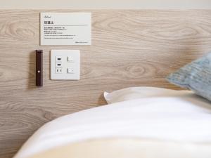a bedroom with a bed with a usb switch and a phone at Super Hotel Premier Akihabara in Tokyo