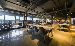 安东市CM Park Hotel的一间有窗户的房间里有桌椅的餐厅