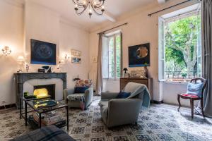 a living room with a fireplace and a couch and chairs at La Féraude - Pays d'Aix en Provence in Gardanne