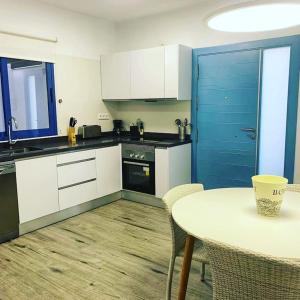 a kitchen with a table and a blue door at Alojamientos 4nudos in San José