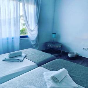 a bedroom with two beds and a table with a window at Alojamientos 4nudos in San José