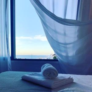 a towel sitting on a bed in front of a window at Alojamientos 4nudos in San José