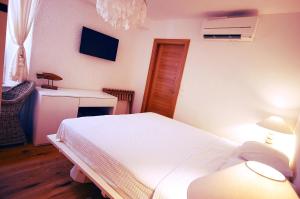 a bedroom with a white bed and a desk at Boutique Hotel Placa in Krk