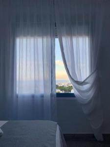 a bedroom with a window with a white curtain at Alojamientos 4nudos in San José
