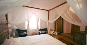 a bedroom with a white bed with a canopy at Boutique Hotel Placa in Krk
