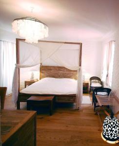 a bedroom with a canopy bed and a chandelier at Boutique Hotel Placa in Krk