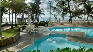 a swimming pool with a view of the ocean at flat apt mobiliado beira mar in Recife